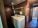 Functional laundry room with wooden paneling, white washer and dryer, and convenient shelving for storage at 5495 Valley Run St, Hickory, NC 28601