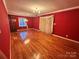 Spacious living room with hardwood floors and chandelier, painted with bold red walls at 5495 Valley Run St, Hickory, NC 28601
