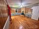Living room with wood paneling, brick fireplace, hardwood floors, and diamond patterned wallpaper at 5495 Valley Run St, Hickory, NC 28601