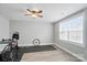 Bright bedroom featuring a ceiling fan, large window, and light wood-look flooring, creating a versatile living space at 5723 Notch Peak Ave, Indian Land, SC 29707