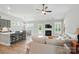 Bright, open-concept living room with fireplace, fan, and seamless flow to kitchen at 5723 Notch Peak Ave, Indian Land, SC 29707