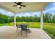 Covered patio with an outdoor dining set, offering a relaxing view of the lush backyard and landscaping at 5723 Notch Peak Ave, Indian Land, SC 29707