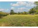 Lush backyard with well-maintained green grass, mature trees, a fire pit area, and a small storage building at 6024 Highview Rd, Weddington, NC 28104