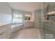 Bright bathroom with a soaking tub, glass shower, and double vanity sinks at 6024 Highview Rd, Weddington, NC 28104