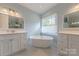 Bright bathroom features white cabinets, a soaking tub, and updated fixtures at 6024 Highview Rd, Weddington, NC 28104