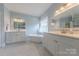 Bright bathroom with double sinks, quartz countertops, a soaking tub and glass shower at 6024 Highview Rd, Weddington, NC 28104