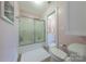 Bright bathroom with shower and bathtub combination, sliding glass door, and tile flooring at 6024 Highview Rd, Weddington, NC 28104