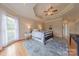 Comfortable bedroom features a tray ceiling with a ceiling fan and plush area rug at 6024 Highview Rd, Weddington, NC 28104