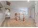 Spacious hallway with carpeted floors, wooden banisters, and multiple doors at 6024 Highview Rd, Weddington, NC 28104