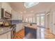 Open kitchen with stainless appliances, island, and view to the outdoor deck at 6024 Highview Rd, Weddington, NC 28104