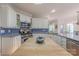 Cozy kitchen featuring white cabinetry, blue backsplash, and center island at 6024 Highview Rd, Weddington, NC 28104