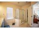 Bright bathroom featuring a glass-enclosed shower, neutral tile floors, and ample vanity space at 6310 Highland Commons Rd, Charlotte, NC 28269