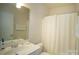 Bright bathroom features a white vanity, toilet, and shower with a neutral-colored curtain at 6310 Highland Commons Rd, Charlotte, NC 28269