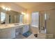 Bathroom featuring double vanity, a large mirror, and enclosed glass shower, offering a serene retreat at 6310 Highland Commons Rd, Charlotte, NC 28269
