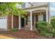 Inviting brick home with a covered porch, rocking chairs, and well-kept landscaping at 6310 Highland Commons Rd, Charlotte, NC 28269