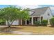 Brick home featuring a covered porch, two-car garage, and mature tree in the landscaped front yard at 6310 Highland Commons Rd, Charlotte, NC 28269