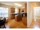 Well-lit kitchen with wooden cabinets, black appliances, hardwood flooring, and a granite countertop island at 6310 Highland Commons Rd, Charlotte, NC 28269
