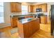 Bright kitchen featuring wood cabinets, granite countertops, a kitchen island, and hardwood floors at 6310 Highland Commons Rd, Charlotte, NC 28269