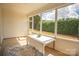 Sunroom with sliding doors, neutral tones, a leaf-patterned rug and view of green outdoor foliage at 6310 Highland Commons Rd, Charlotte, NC 28269