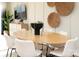 Modern dining room with a light wood table, white chairs, stylish wall decor, and ample natural light at 7108 Hodges Meadow Ln, Charlotte, NC 28213