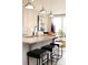 Kitchen island with stone countertops, modern pendant lighting, and seating for three at 7108 Hodges Meadow Ln, Charlotte, NC 28213