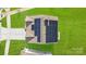 Aerial view of a home's roof featuring solar panels, lush green lawn, and paved driveway at 7205 Finnigan Rd, Charlotte, NC 28215