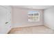 Bright bedroom featuring neutral walls, carpet, closet, and a large window at 7205 Finnigan Rd, Charlotte, NC 28215