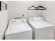 Laundry room featuring a white washer and dryer with overhead shelving at 7205 Finnigan Rd, Charlotte, NC 28215