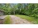 Gravel driveway leading to the backyard, surrounded by lush trees and greenery at 7860 Henry Harris Rd, Fort Mill, SC 29707