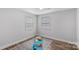 Bright bedroom with wood-look floors, neutral walls, and natural light from the two windows at 7860 Henry Harris Rd, Fort Mill, SC 29707