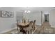 Dining room featuring a chandelier, a wooden table seating four, and neutral gray paint at 7860 Henry Harris Rd, Fort Mill, SC 29707
