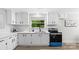 Modern kitchen with white cabinets, new appliances, stainless steel sink, and views of the green backyard at 7860 Henry Harris Rd, Fort Mill, SC 29707