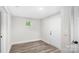 Neutral room featuring wainscoting and an entry door, with wood-look floors at 7860 Henry Harris Rd, Fort Mill, SC 29707
