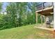 Backyard with covered deck, grill, green grass, and view of the mature trees at 862 Kathy Dianne Dr, Fort Mill, SC 29707