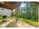 Backyard patio with grill, wooden beams, green grass, and view of the mature trees at 862 Kathy Dianne Dr, Fort Mill, SC 29707