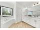 Bright bathroom with dual sinks, white cabinets, and an oversized tub under a window with natural light at 862 Kathy Dianne Dr, Fort Mill, SC 29707
