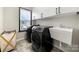 Well-lit laundry room featuring modern appliances, white cabinets, and a sink near a bright window at 862 Kathy Dianne Dr, Fort Mill, SC 29707