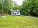 Traditional home surrounded by lush greenery, featuring a classic design with dormer windows and a spacious front yard at 8905 Vagabond Rd, Mint Hill, NC 28227