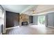 Living room with a striking stone fireplace, neutral walls, fan, new flooring, and sliding glass doors at 8905 Vagabond Rd, Mint Hill, NC 28227