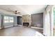 Inviting living area featuring a stone fireplace, ceiling fan, new flooring, and a well-lit atmosphere at 8905 Vagabond Rd, Mint Hill, NC 28227