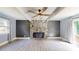 Open-concept living room featuring a stone fireplace, ceiling fan, and sliding glass doors for seamless indoor-outdoor living at 8905 Vagabond Rd, Mint Hill, NC 28227
