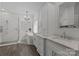 Bright bathroom with white vanity, soaking tub, glass shower, stylish chandelier, and wood look floors at 9625 Donna Ve Ln, Charlotte, NC 28277
