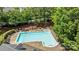 An aerial shot shows a sparkling community pool with sun loungers and tables surrounded by mature landscaping at 9625 Donna Ve Ln, Charlotte, NC 28277