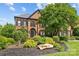 Two-story brick home with a well manicured front yard and large shade tree at 9625 Donna Ve Ln, Charlotte, NC 28277