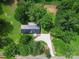 An aerial view of a beautiful single-story home surrounded by lush greenery and a gravel driveway at 10379 Turnplow Dr, Davidson, NC 28036