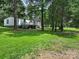 Expansive backyard with manicured lawn and back deck overlooking the tree line at 10379 Turnplow Dr, Davidson, NC 28036