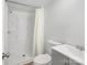A minimalist bathroom featuring white fixtures and a shower-tub combo with shower curtain at 10379 Turnplow Dr, Davidson, NC 28036