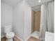 Bathroom featuring a neutral shower with a patterned curtain, toilet, and light wood floors at 10379 Turnplow Dr, Davidson, NC 28036