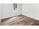 This bedroom has neutral walls, wood-look floors, and a window offering natural light at 10379 Turnplow Dr, Davidson, NC 28036