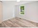 Neutral bedroom featuring a new window, light wood floors, and simple decor at 10379 Turnplow Dr, Davidson, NC 28036